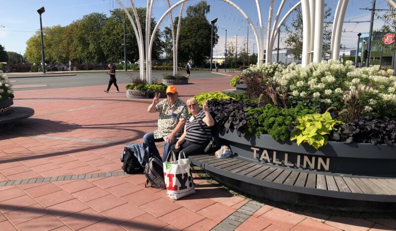 Två personer på en bänk där det står Tallinn